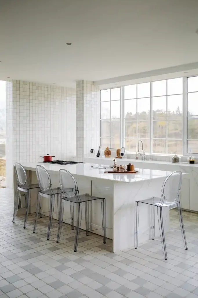 Minimalist acrylic ghost stools arranged around a white marble kitchen island, creating an illusion of spaciousness in a contemporary kitchen" "Industrial-style metal and reclaimed wood bar stools with footrests, paired with a concrete-top kitchen island in a loft-like setting