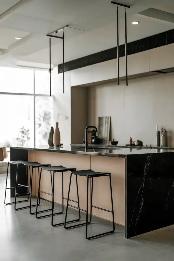 a minimalist Scandinavian-style kitchen island featuring light wood accents and a set of sleek, white bar stools with natural wood legs.