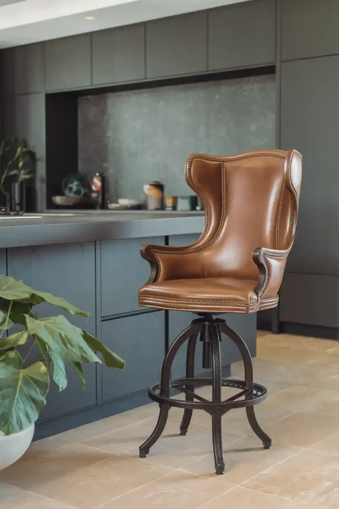 Swivel Bar Stool: Depict a stylish swivel bar stool with a high back and leather upholstery, situated at a contemporary kitchen island.