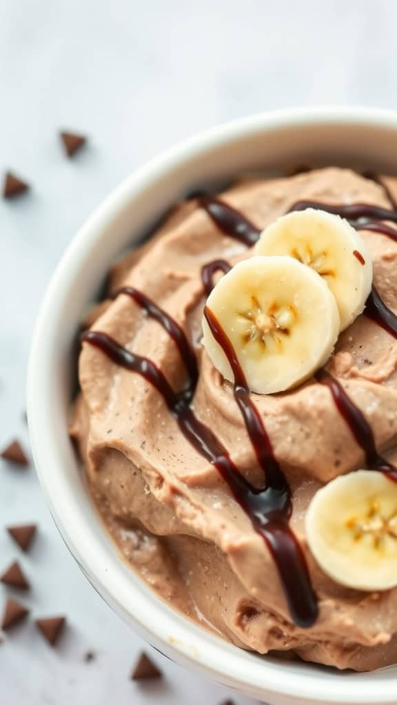 A bowl of chocolate banana cottage cheese dessert topped with banana slices and chocolate drizzle.