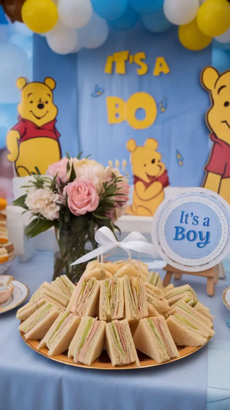 A display of tea sandwiches at a Winnie the Pooh themed gender reveal party with a sign that says 'It's a Boy.'