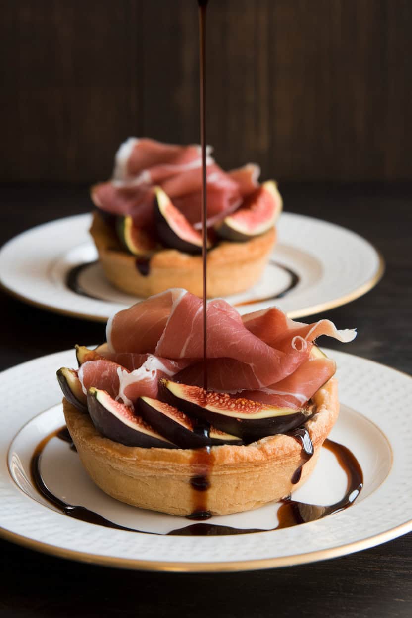 Two puff pastry tarts topped with sliced figs and prosciutto, drizzled with balsamic reduction